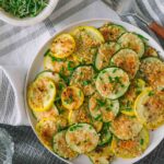 roasted sumemr squash and zucchini on a plate with chives.