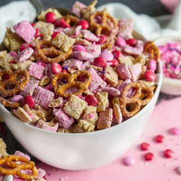bowl of pink valentines day puppy chow in a white bowl.