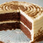 chocolate cake with white buttercream on cake plate.