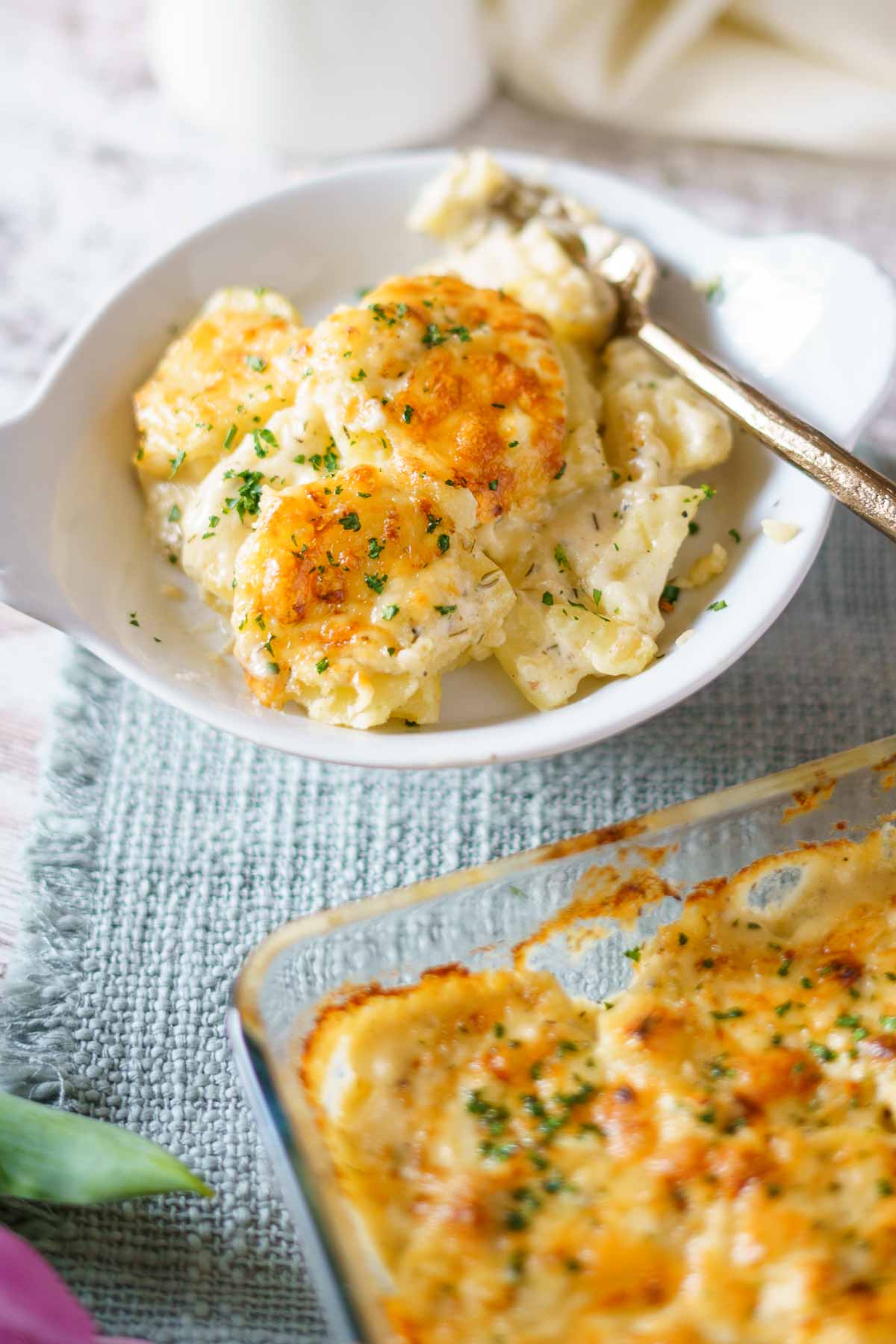 serving on cheesy potatoes on a plate with a fork. 