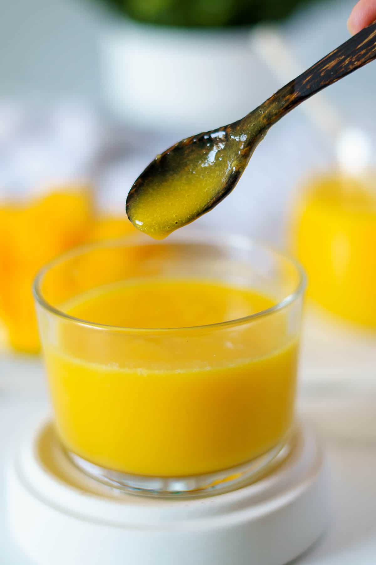 mango nectar being spooned from a jar.  