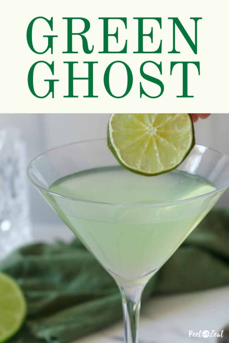 garnishing green cocktail with a lime.