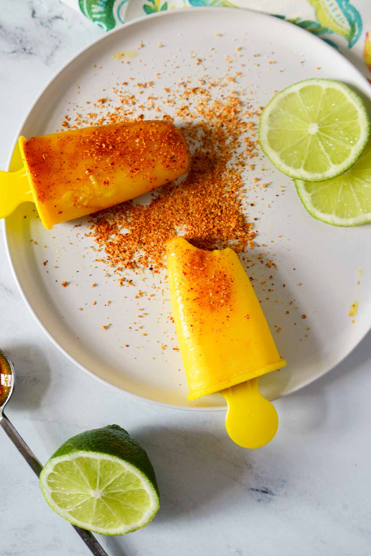 sprinkling mango popsicles with tajin seasoning. 