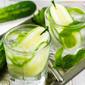 two gin and tonics with cucumbers and mint