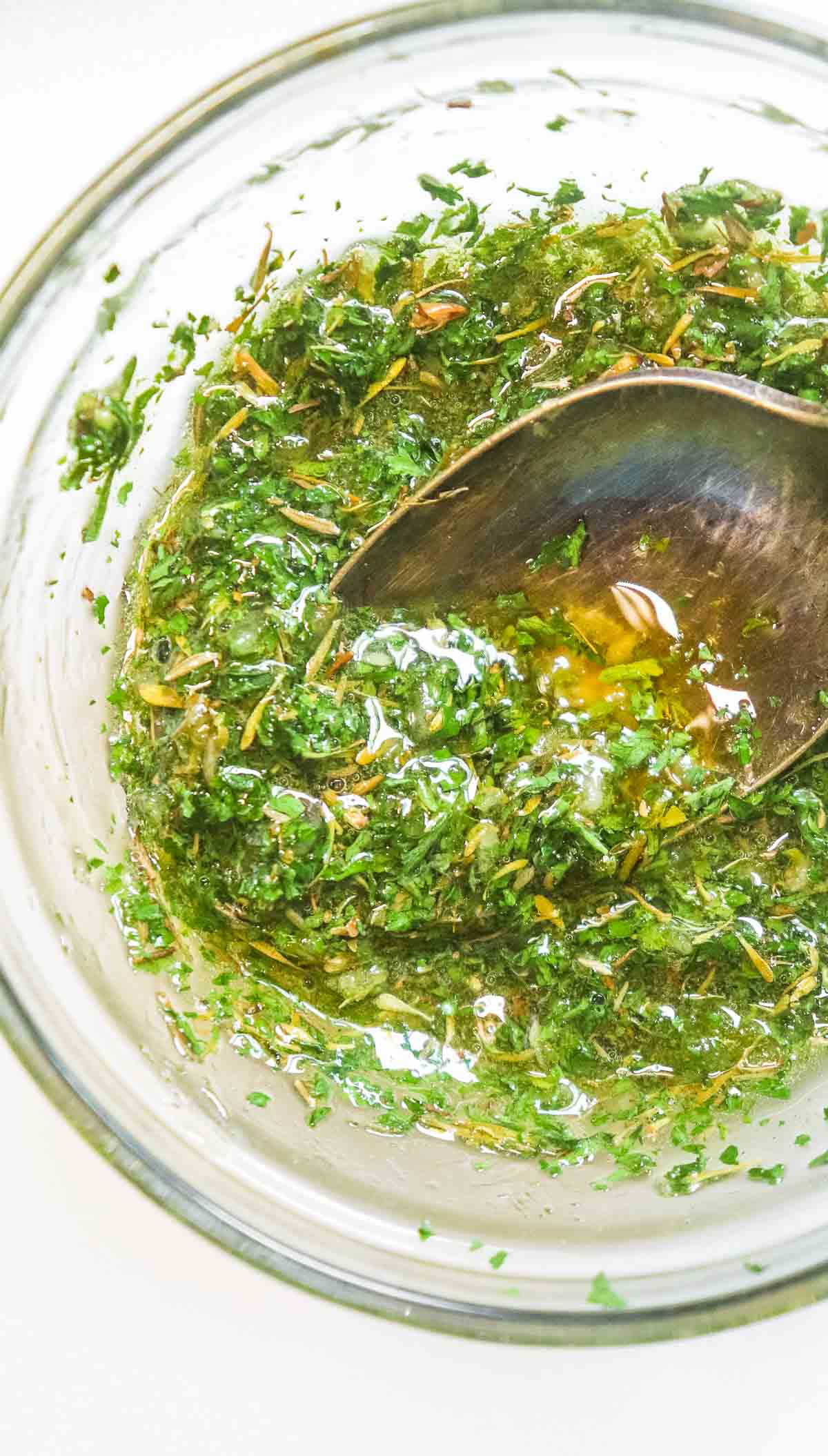 herb dressing in a bowl with a spoon