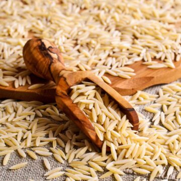 dried orzo on wooden spoon