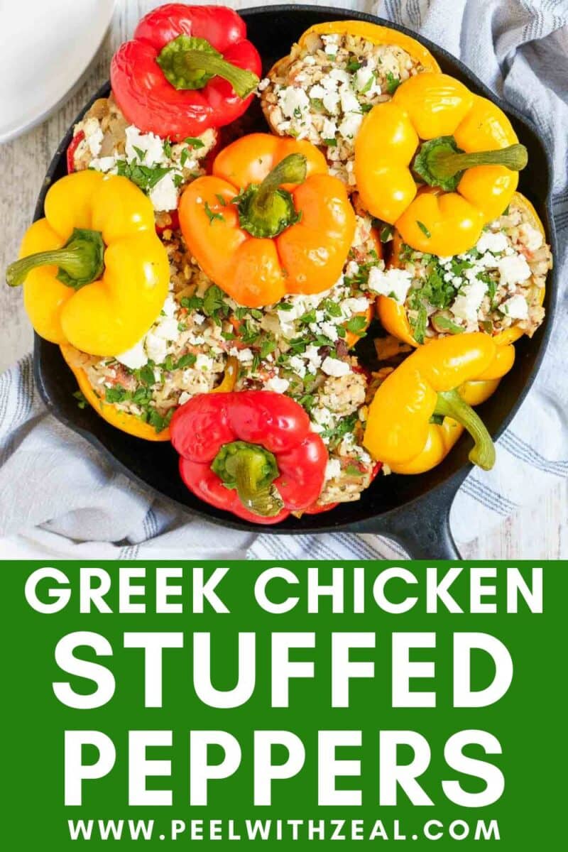 A skillet filled with red and yellow bell peppers stuffed with a savory Greek chicken and feta mixture, made with ground chicken, garnished with herbs. Text below reads: "Greek Chicken Stuffed Peppers www.peelwithzeal.com".