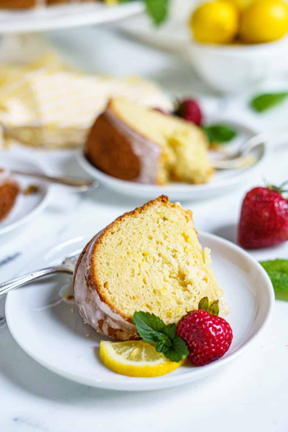 slice of lemon cake on plate with strawberries
