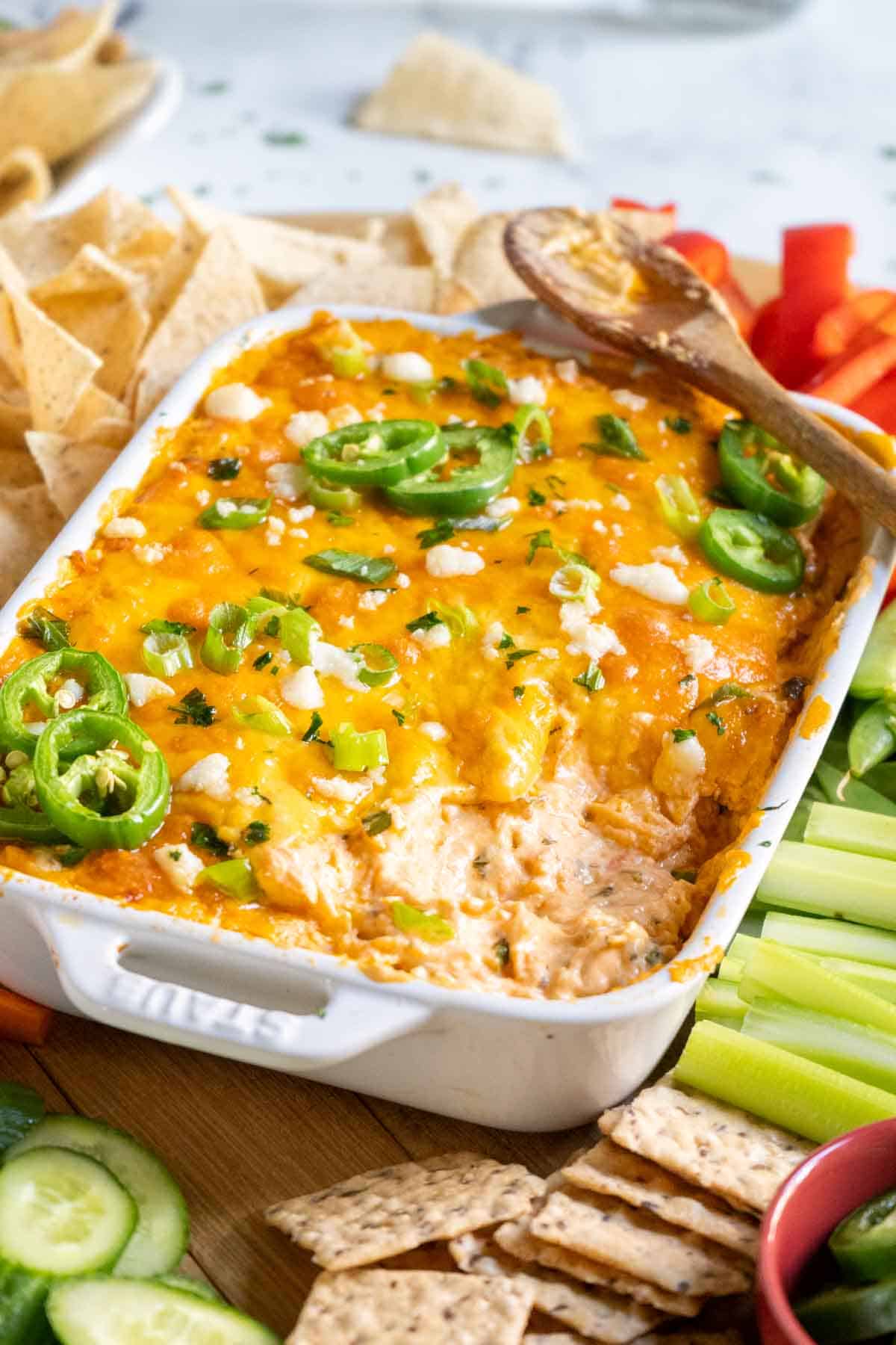 Buffalo chicken dip baked in a white dish.