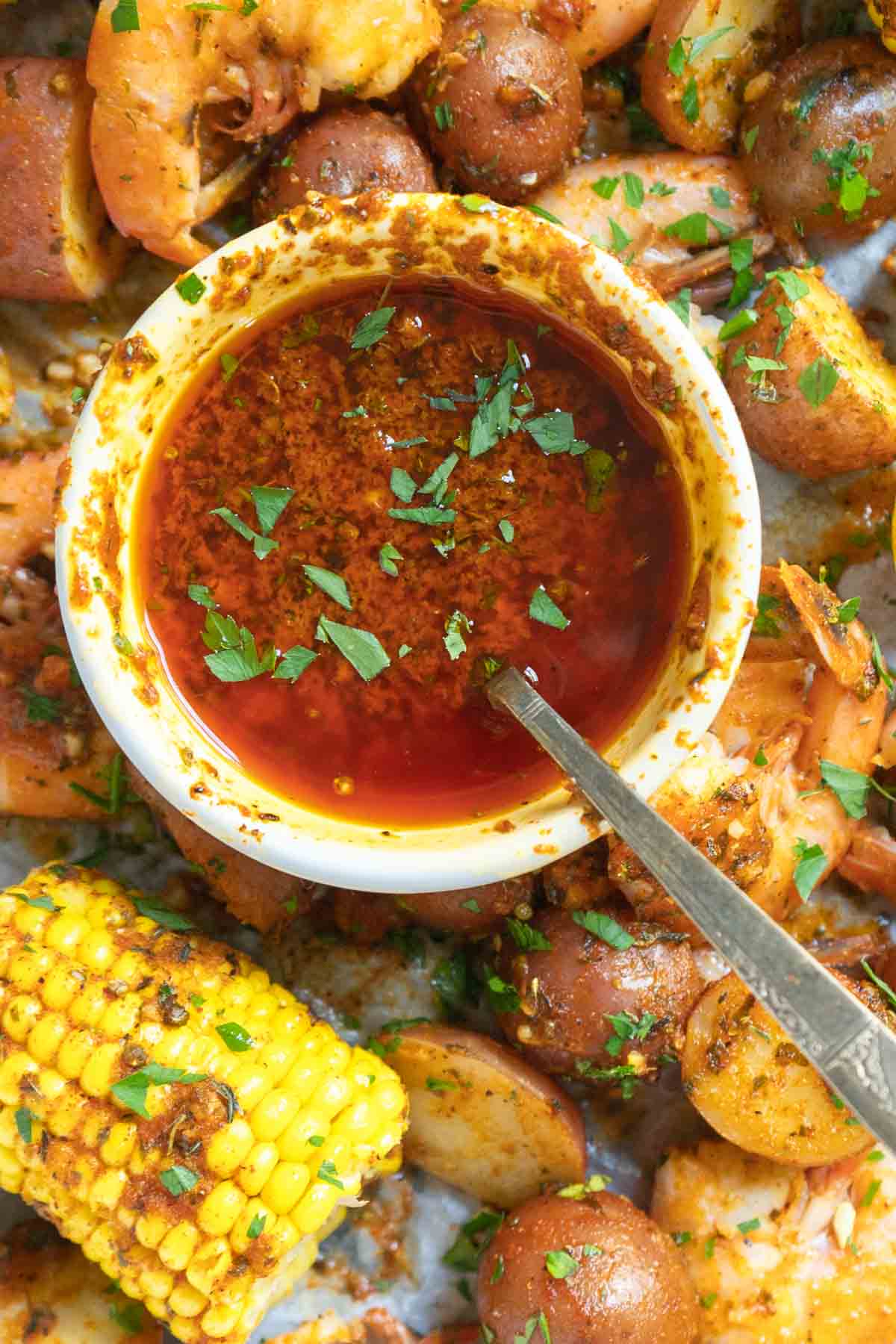 Cajun butter sauce in a white bowl with a spoon.