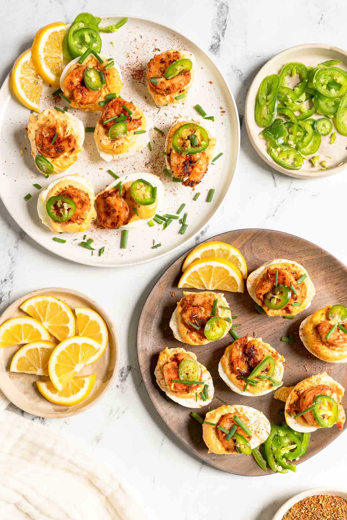 Cajun deviled eggs with shrimp on serving platters.