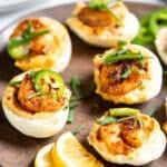 Cajun deviled eggs with shrimp in a serving platter.