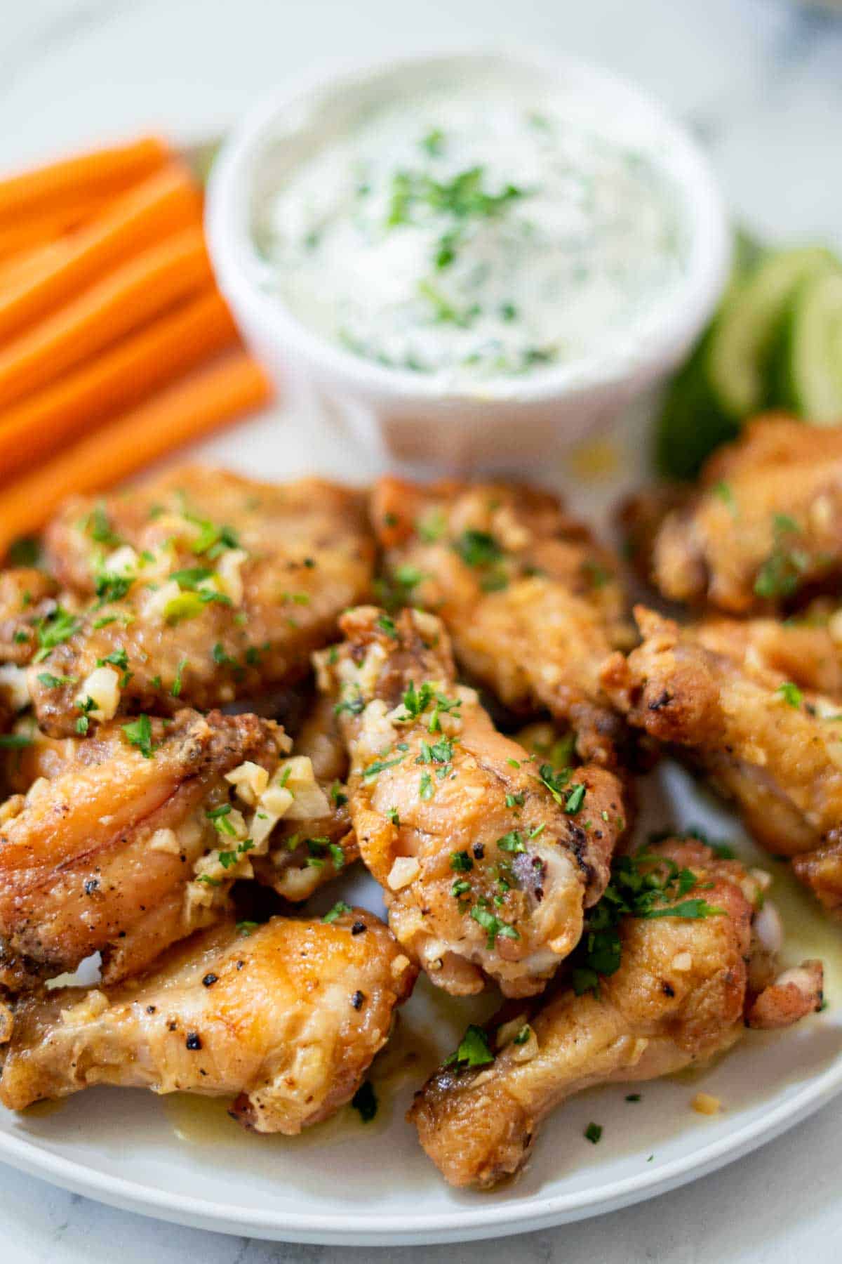 Garlic chicken wings with herbs on a plate.