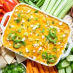 Buffalo chicken dip baked in a white dish.