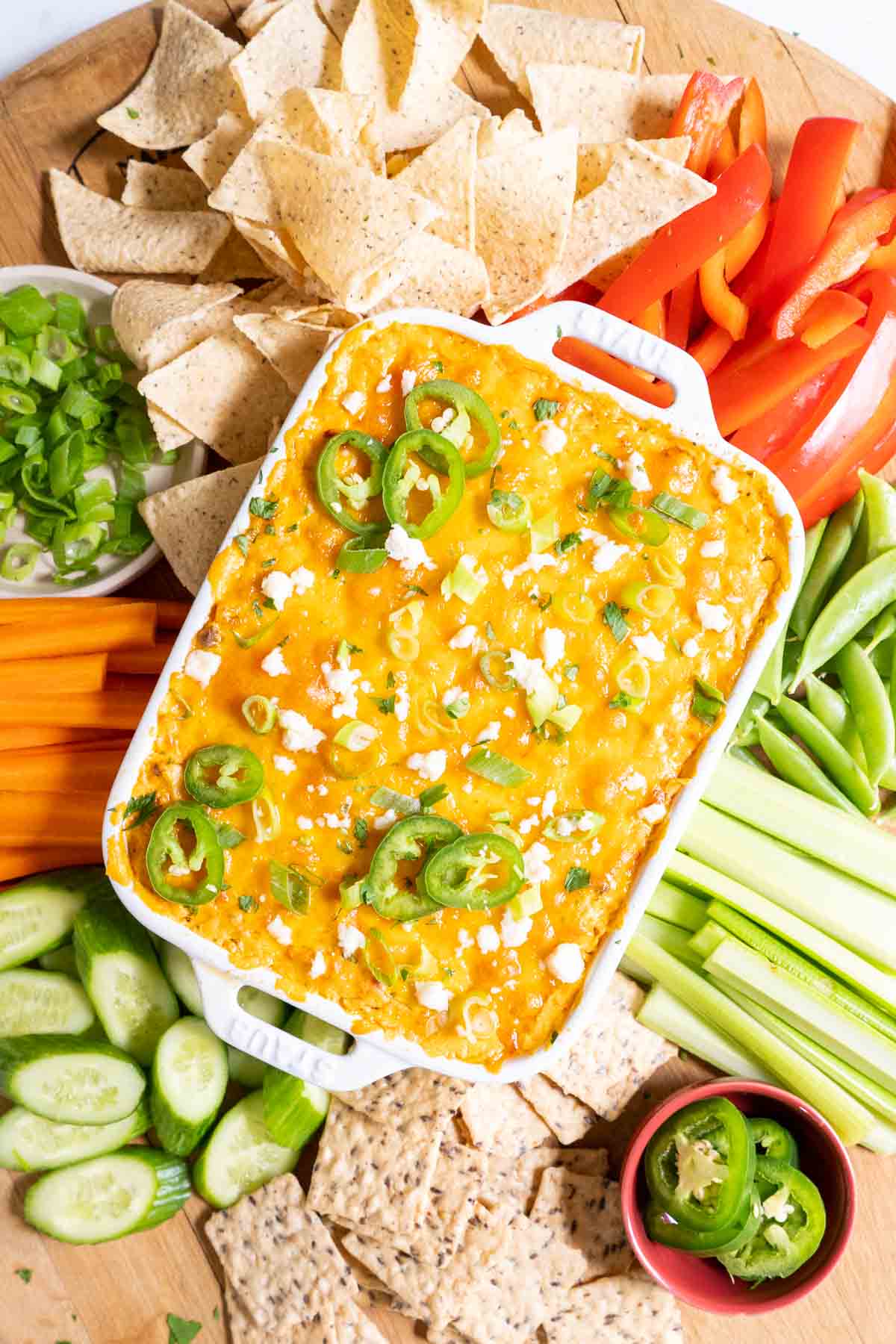 Buffalo chicken dip baked in a white dish. Served with crackers and veggies.
