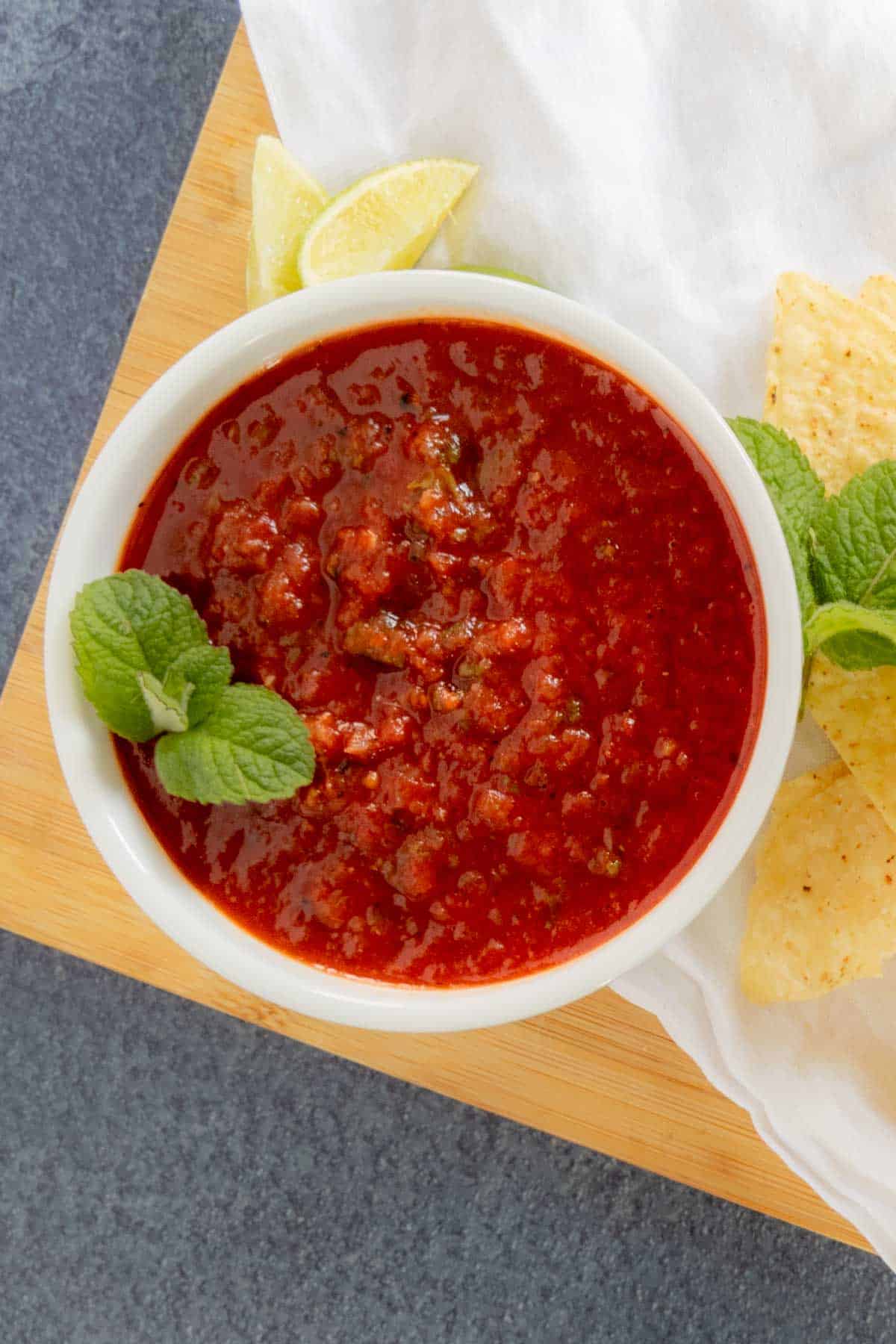 Mint garnish on salsa in white bowl.