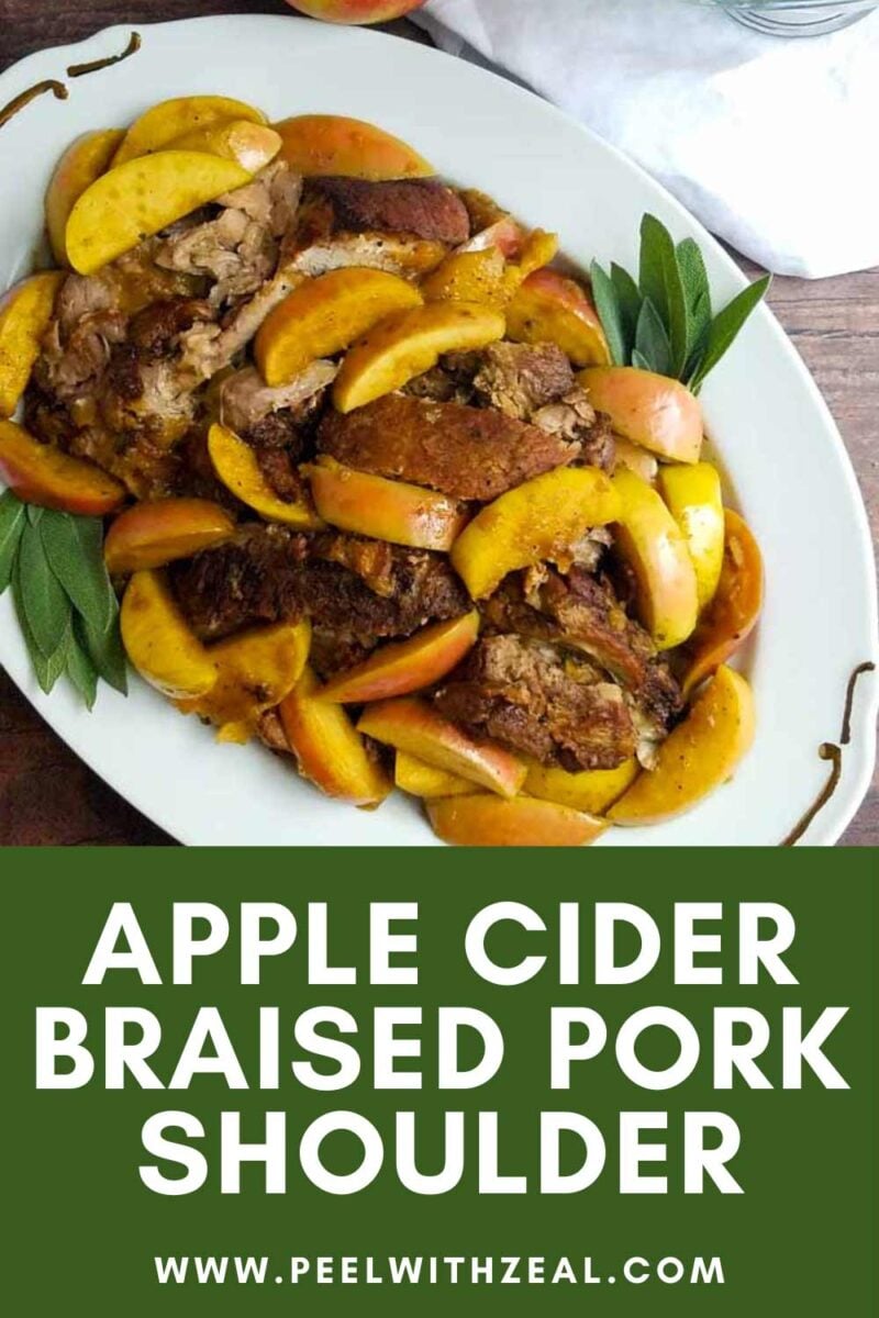 Pork shoulder on a platter with apples and pan sauce.