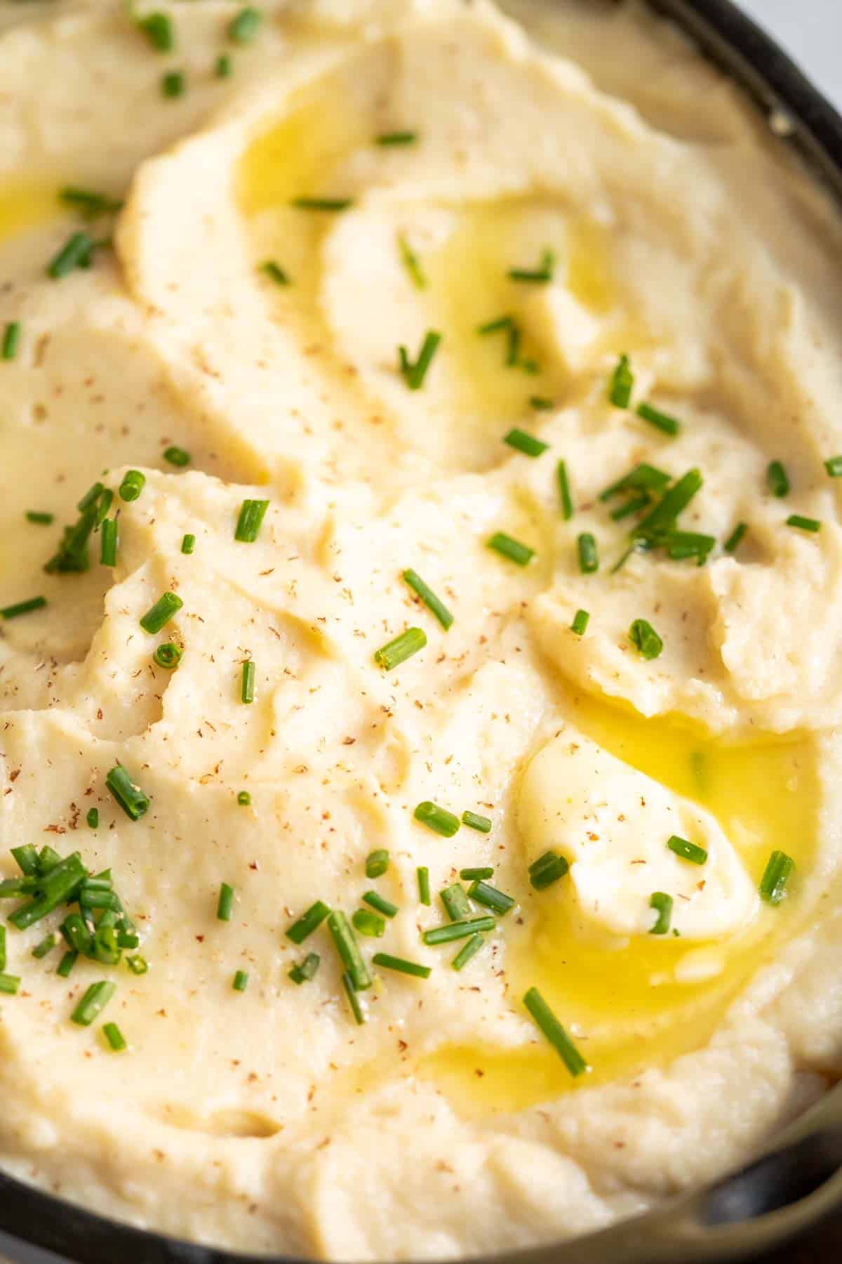 Celeriac puree in a bowl with butter and chives.