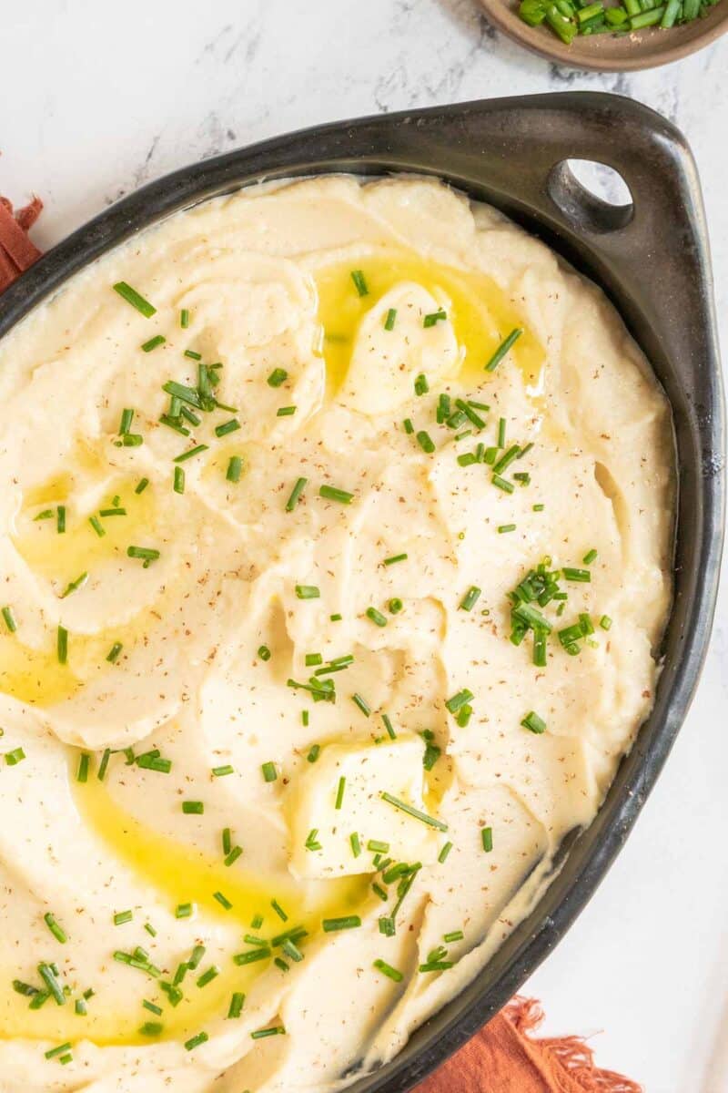 Celeriac puree in a bowl with butter and chives.