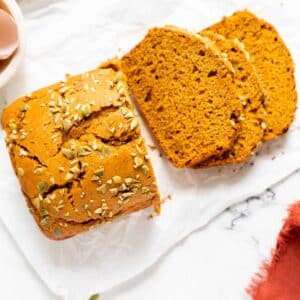 Loaf of gluten-free pumpkin bread with 3 slices cut off.