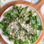 Sauteed kale on a plate and topped with parmesan cheese.