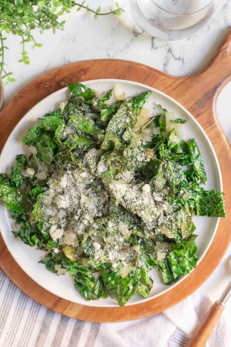 Sauteed kale on a plate and topped with parmesan cheese.