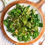 Sauteed greens on a plate with onions and garlic.