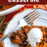 Sweet potato casserole on a plate with pecans and whipped cream.