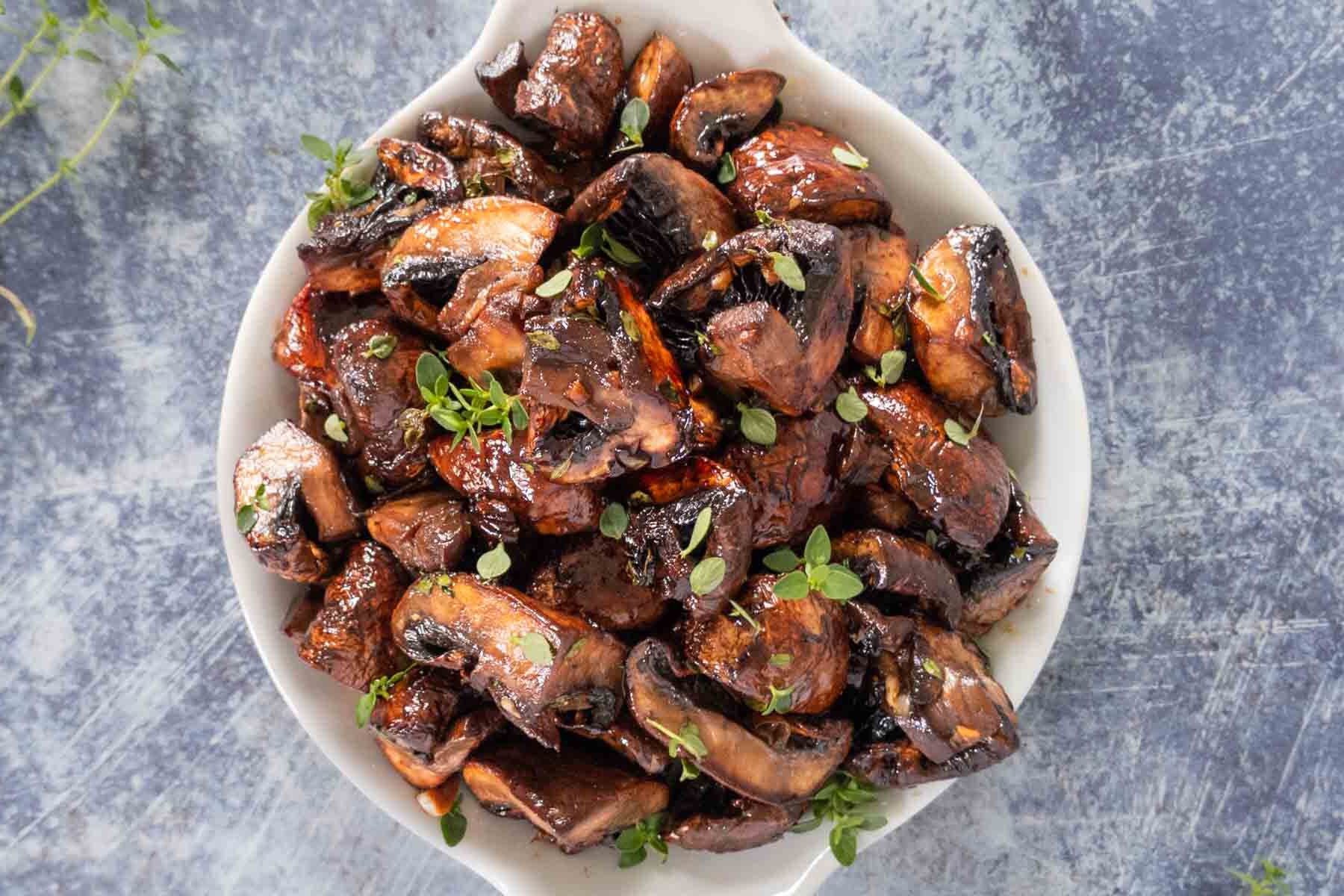 Oven roasted mushrooms with a balsamic glaze in a serving dish.