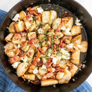Roasted turnips topped with bacon and cheese in a cast iron skillet.