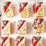 Rice cereal treats decorated with red and green on a baking sheet.