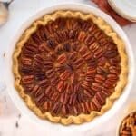 Pecan pie in a white pie pan.