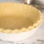 Gluten free pie dough in a white pie plate.