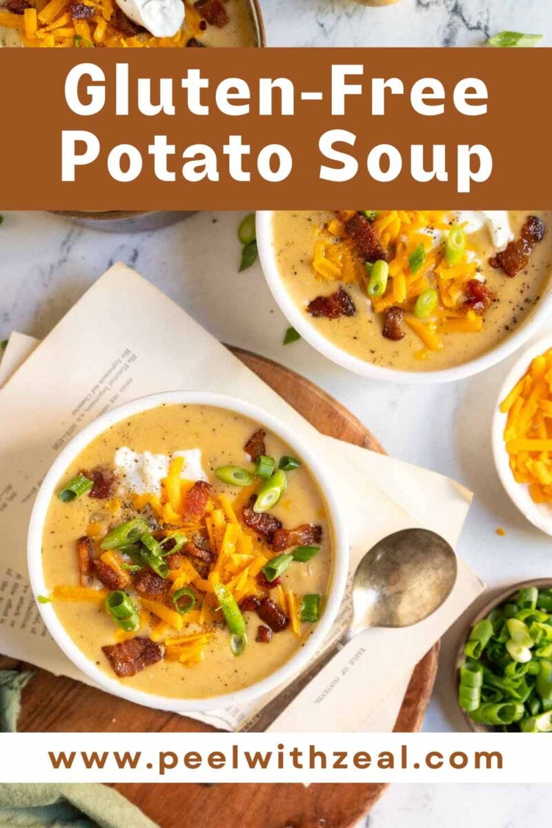 Potato soup in white bowl with bacon and cheese with a spoon.