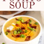 Potato soup in white bowl with bacon and cheese.