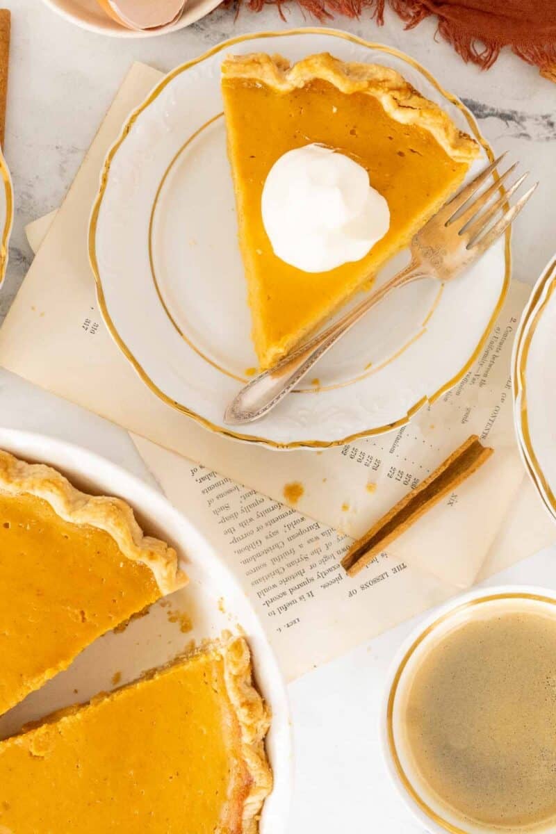 Slice of pie with whipped cream and a cup of coffee.