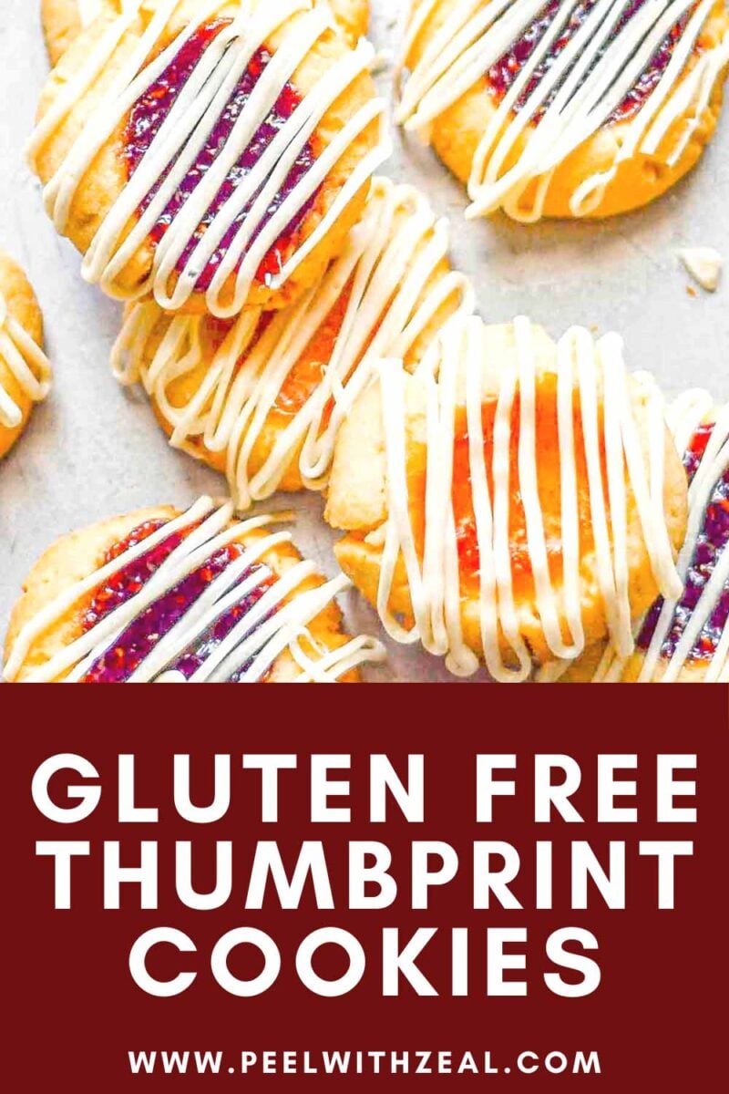 Jam filled thumbprint cookies on a baking sheet.