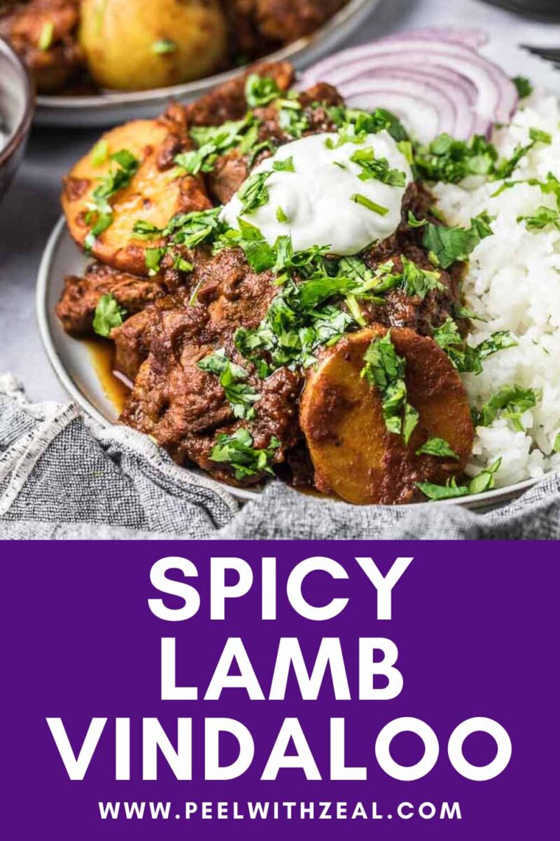 Lamb vindaloo with potatoes served over rice with raita and red onion.