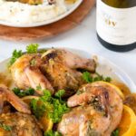 Roasted cornish hens on a plate with gravy.
