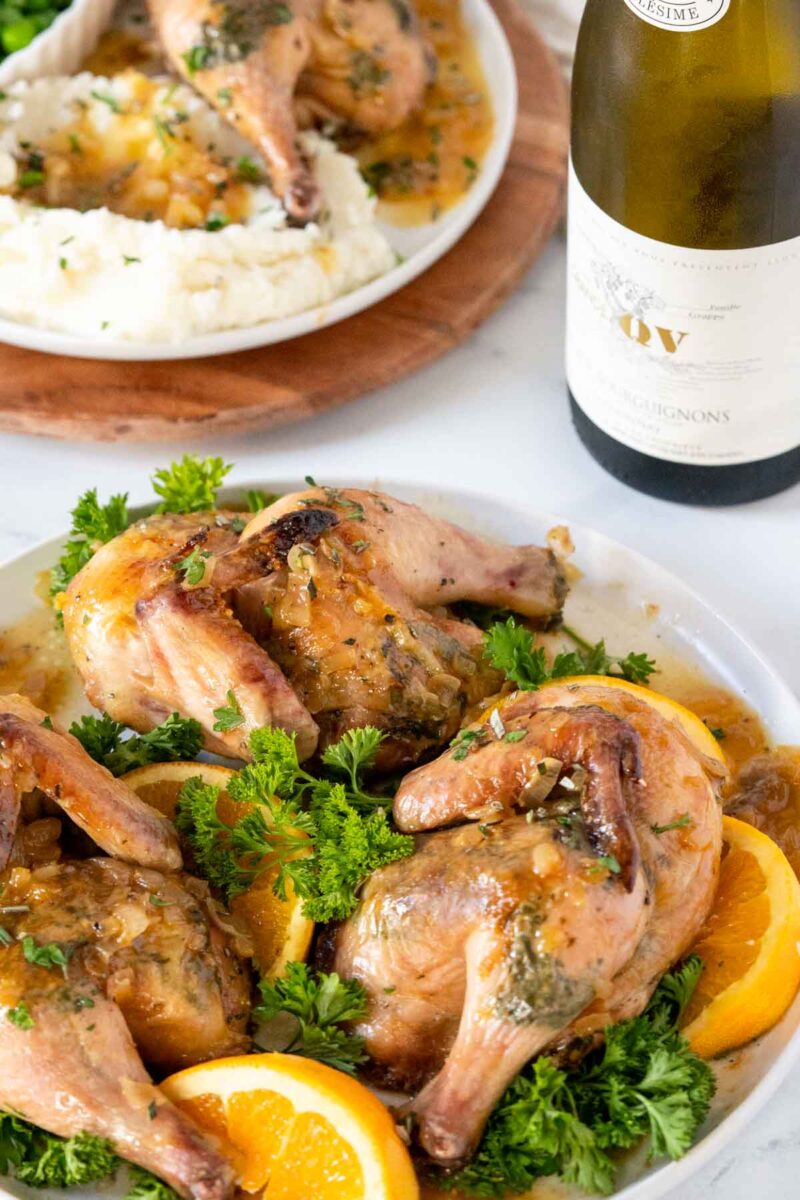 Roasted cornish hens on a plate with gravy.