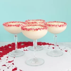 Coupe glasses rimmed with peppermint candy canes and filled with white chocolate mousse.