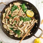 Sausage pasta with broccolini in a pan.