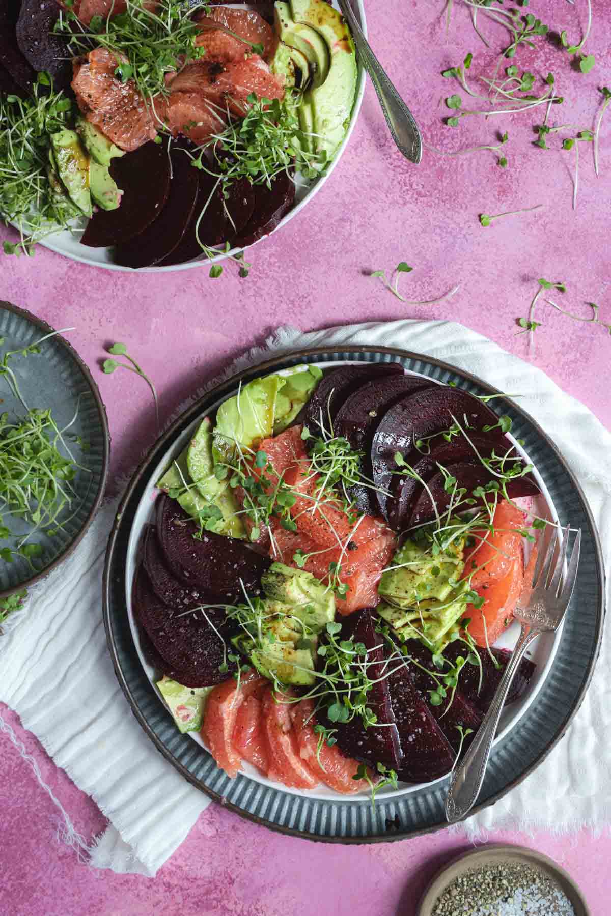 Beet salad on a plate with grapefruit and microgreens.