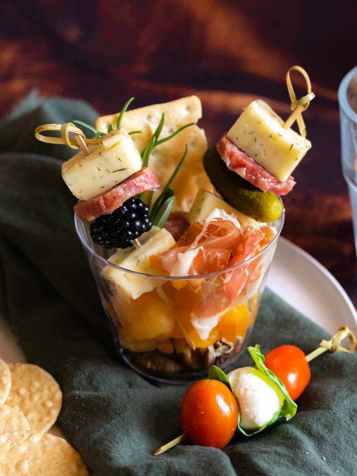 Charcuterie and cheese skewers in a cup.