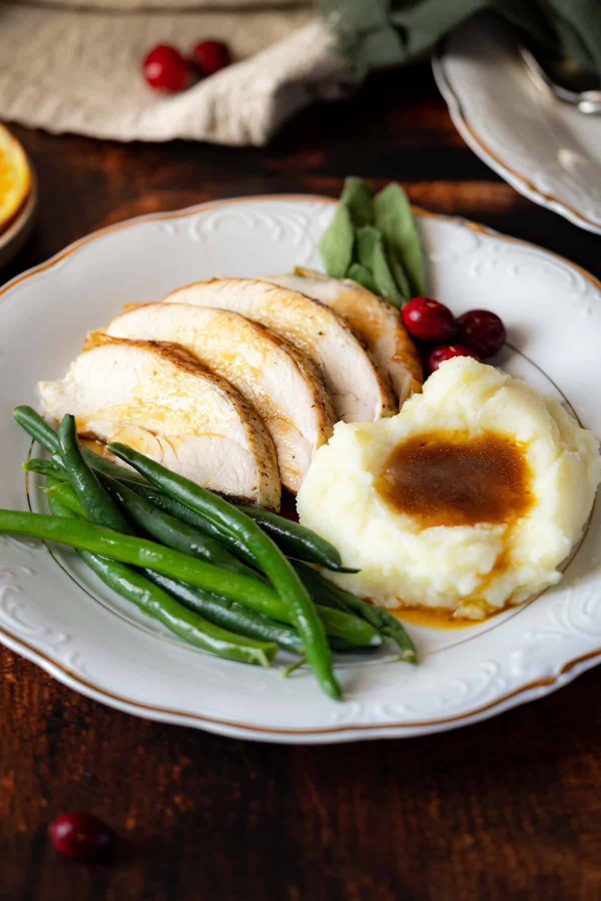 Turkey served with mashed potatoes and green beans.