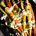 Roasted carrots in a baking dish with lemon dressing.