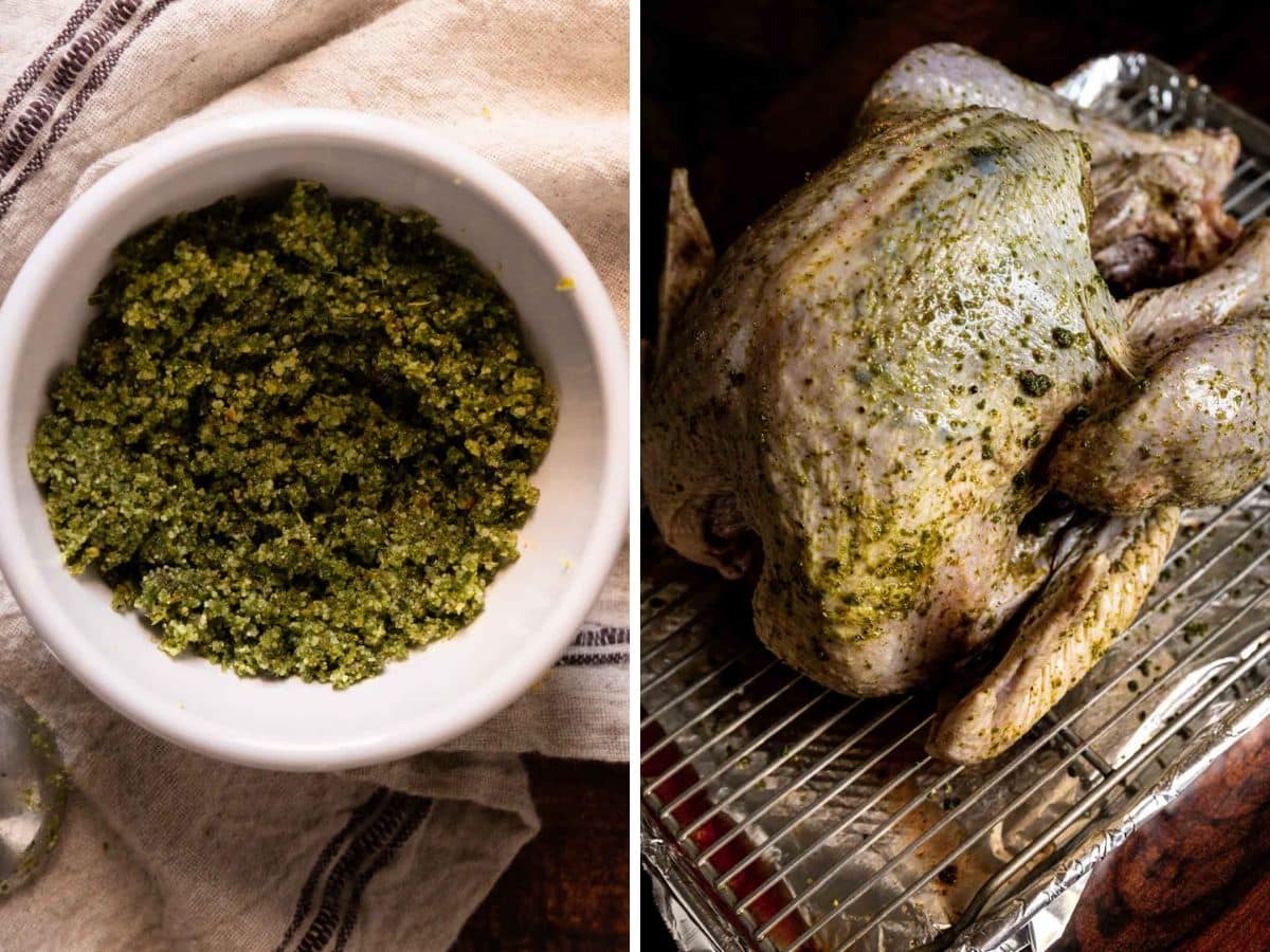 A bowl of green pesto sits on a cloth beside a raw whole roast turkey coated with pesto, resting on a wire rack over a roasting pan.