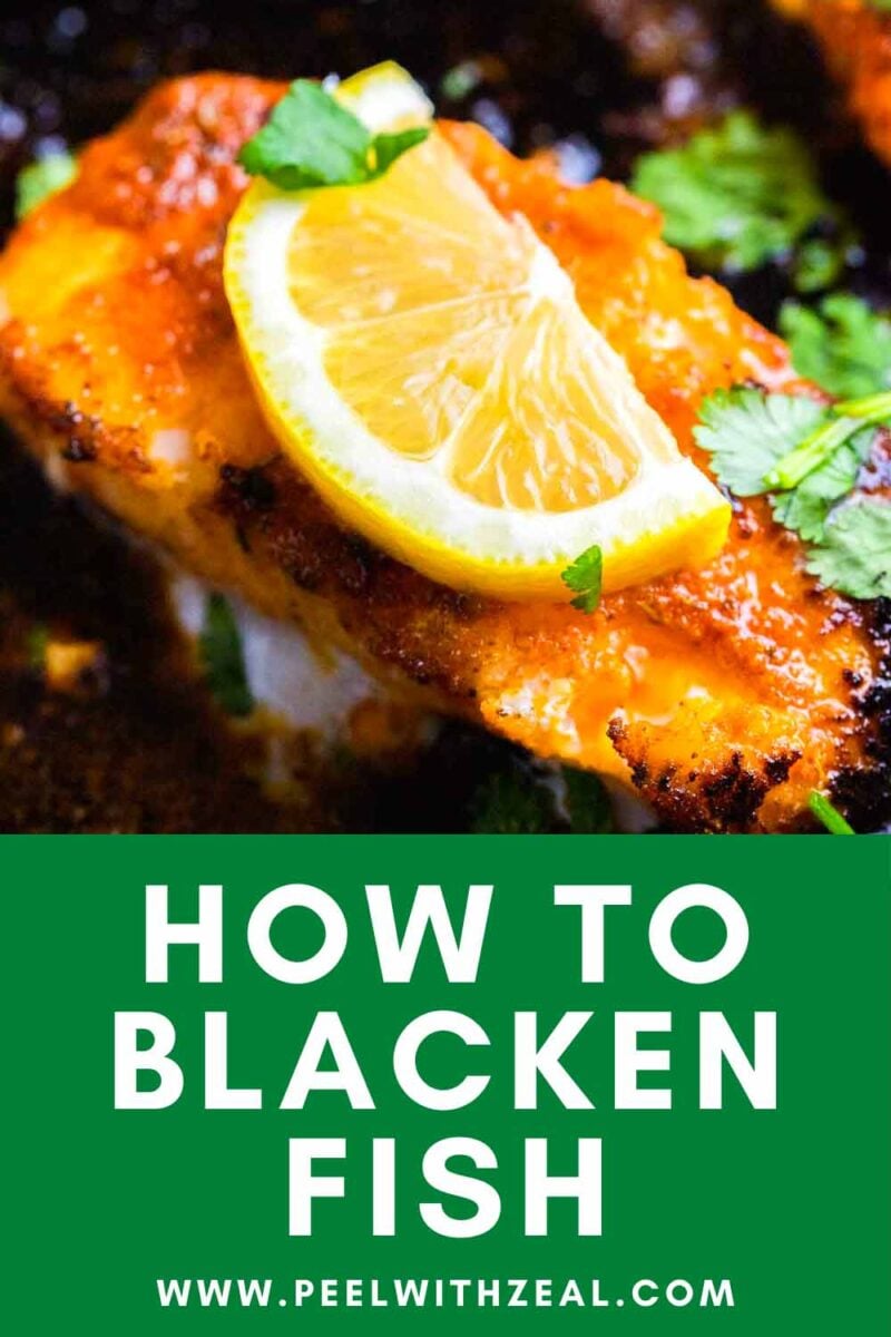 Cajun cod fillet with a slice of lemon in a cast iron pan.