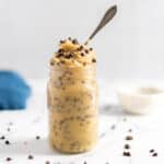 Chocolate chip cookie dough in a jar with a spoon.