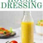 Olive oil based dressing in a bottle with a bunch of red tomatoes.